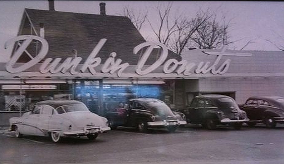 Vintage photo of the first Dunkin' Donuts with 1950s cars parked out front