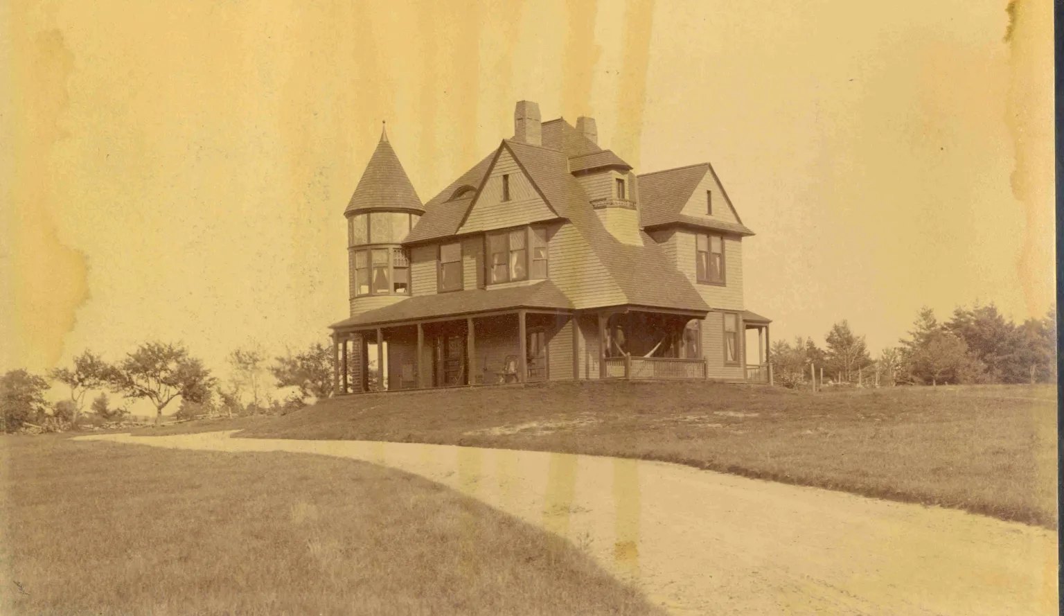 An old sepia photo of a Victorian house with a turret in Hudson