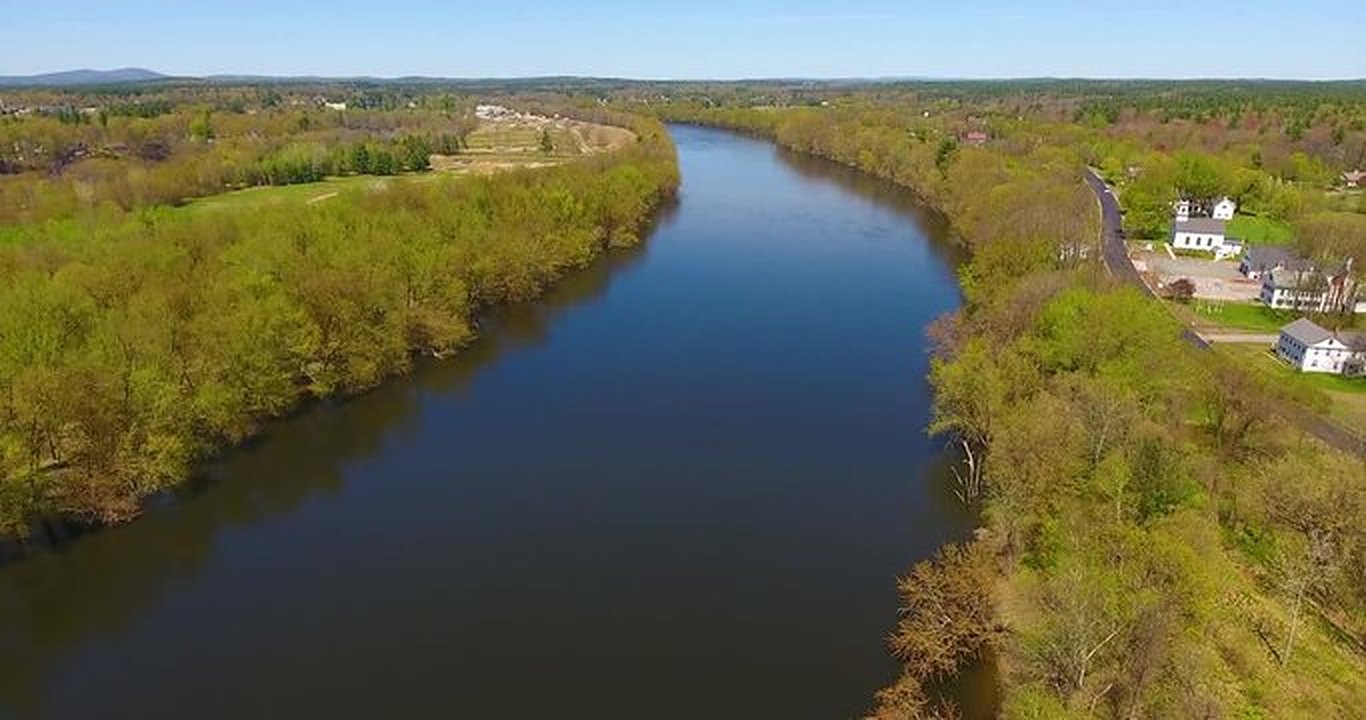 Aerial view of the Merrimack River with wooded banks on both sides