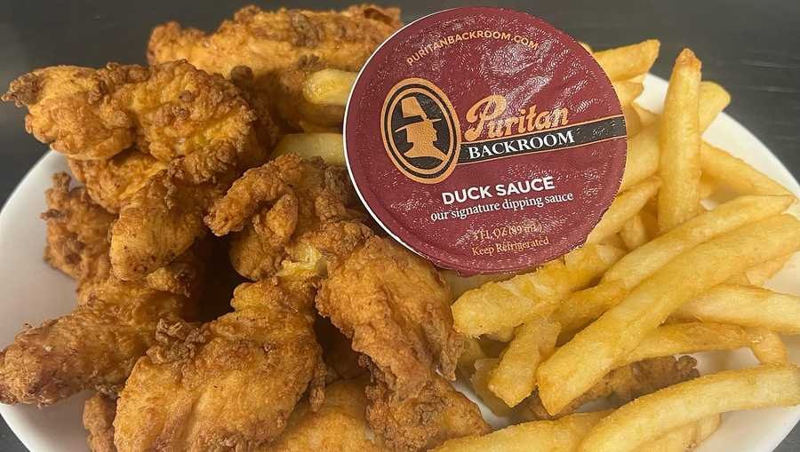 Puritan Backroom chicken tenders and fries with a cup of duck sauce
